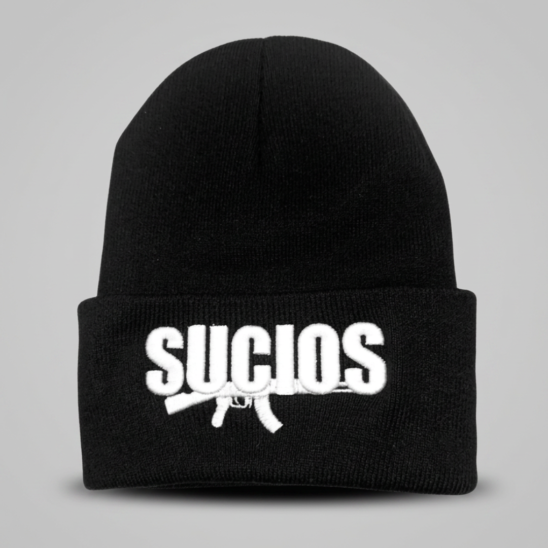 A black knit beanie hat with a white embroidered logo on the front cuff. The logo features the word 'SUCIOS' in bold white letters above a white rifle silhouette.