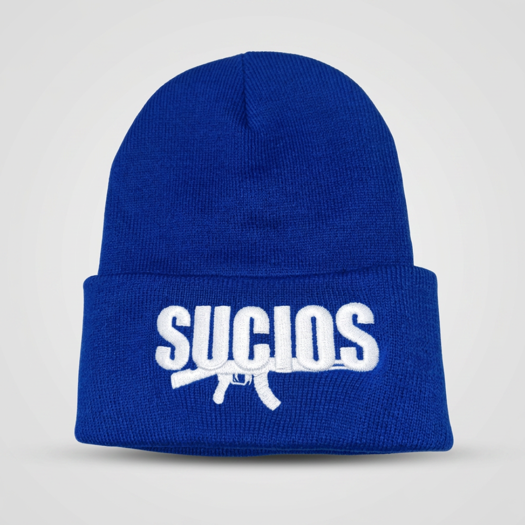 A royal blue knit beanie with a white embroidered logo reading 'SUCIOS' and a rifle graphic on the front cuff, shown against a light gray background.